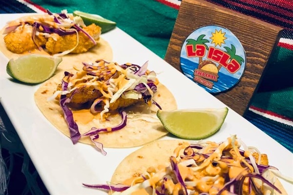 Grab delicious tacos from the La Isla Taco stand.