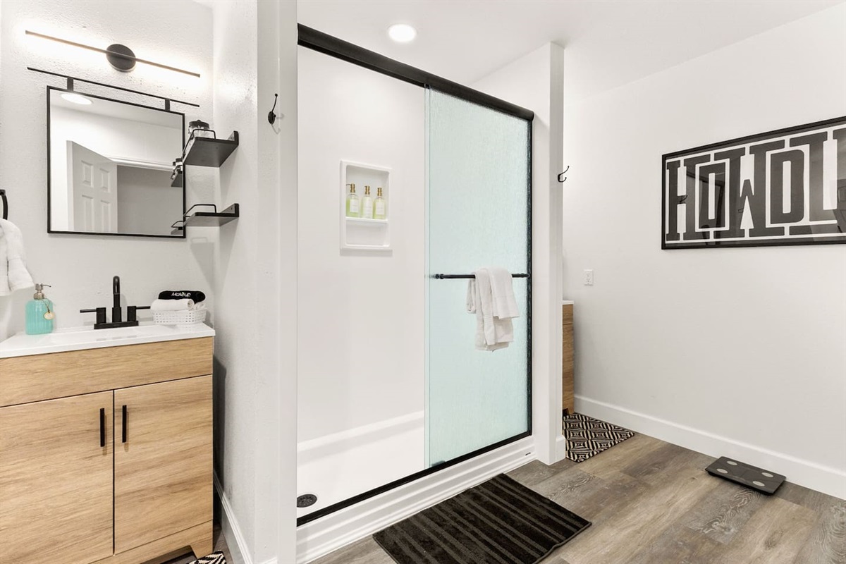 Newly remodeled bathroom with modern wood vanity, matte black fixtures, and a spacious glass walk-in shower. Clean, bright, and stylish, perfect for relaxing, refreshing, and getting ready for your day in comfort and privacy.
