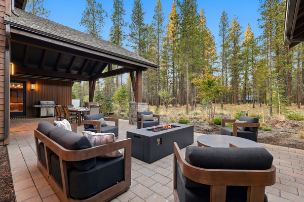 Private outdoor living among the pines, with a gas fire table, lounge seating and covered dining