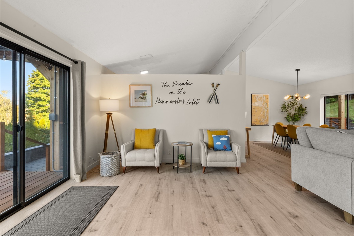 This open front room welcomes you with natural light, comfortable chairs, and a view worth lingering over