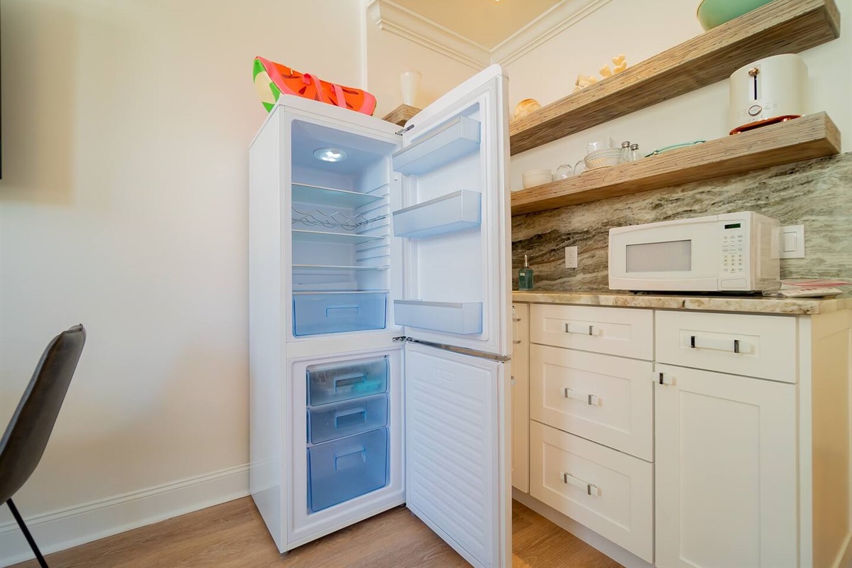 Classic retro refrigerator & freezer will come in handy for longer stays on Palm Beach Island. Pull out trash on the right.