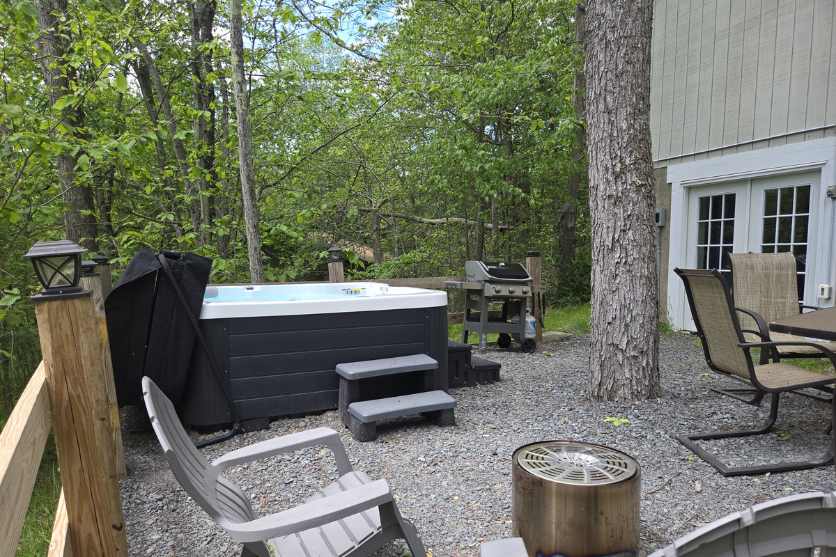 Backyard with hot tub, firepit, weber bbq grill, table with seating