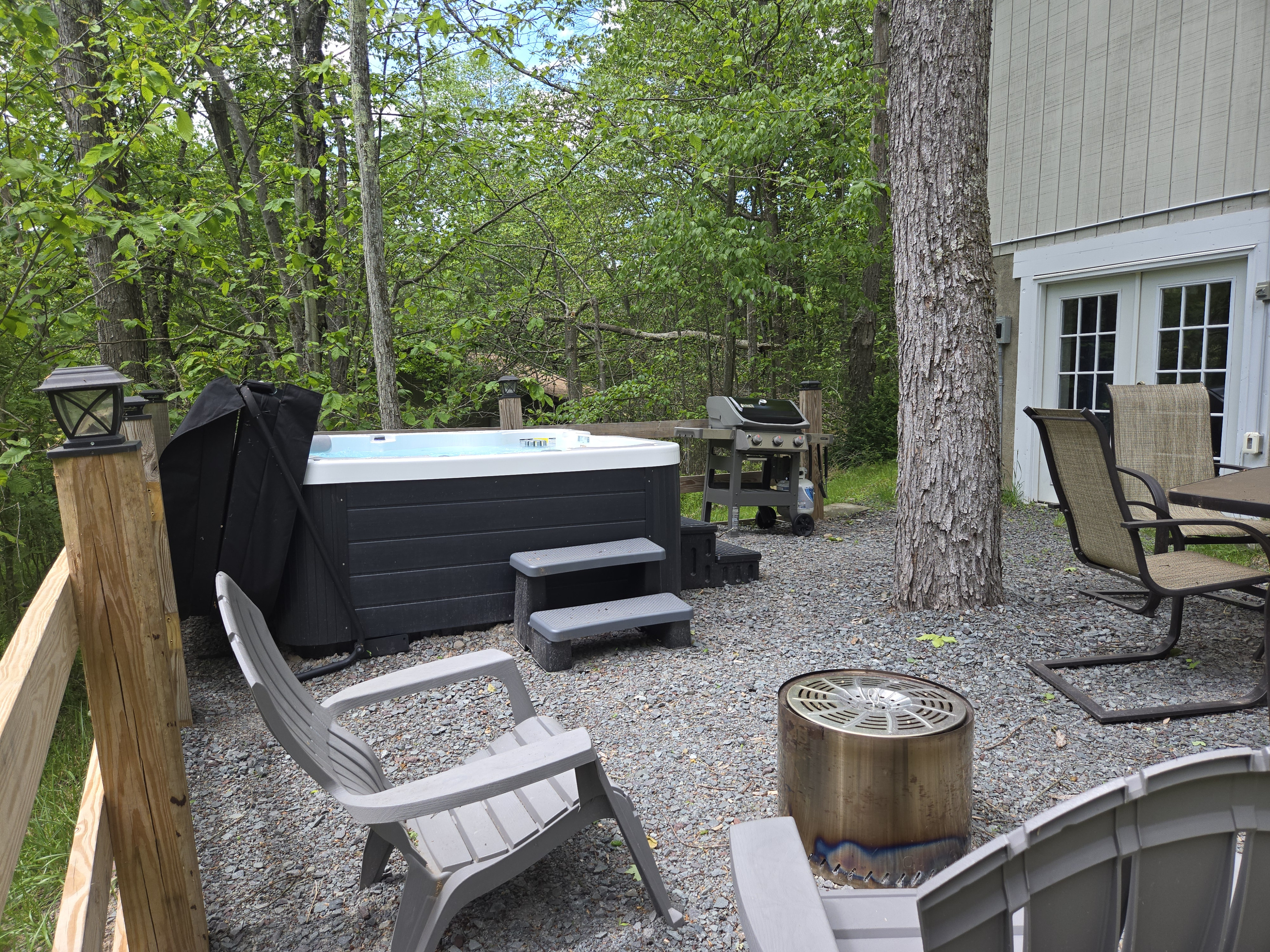 Backyard with hot tub, firepit, weber bbq grill, table with seating
