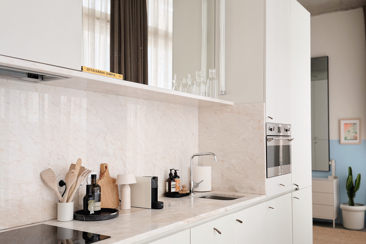 Marble kitchen with dishwasher, induction cooktop, and washer/dryer.