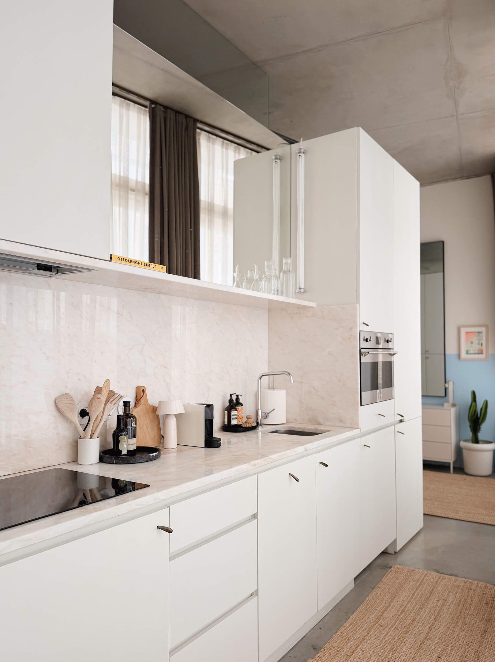 Marble kitchen with dishwasher, induction cooktop, and washer/dryer.