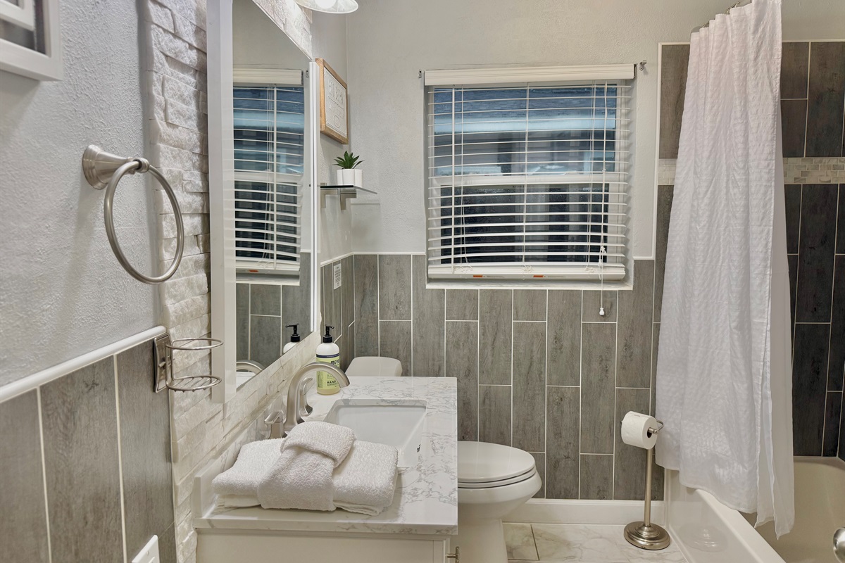 With its large mirror, natural light, and neutral palette, this bathroom offers a refreshing start and relaxing end to your day.