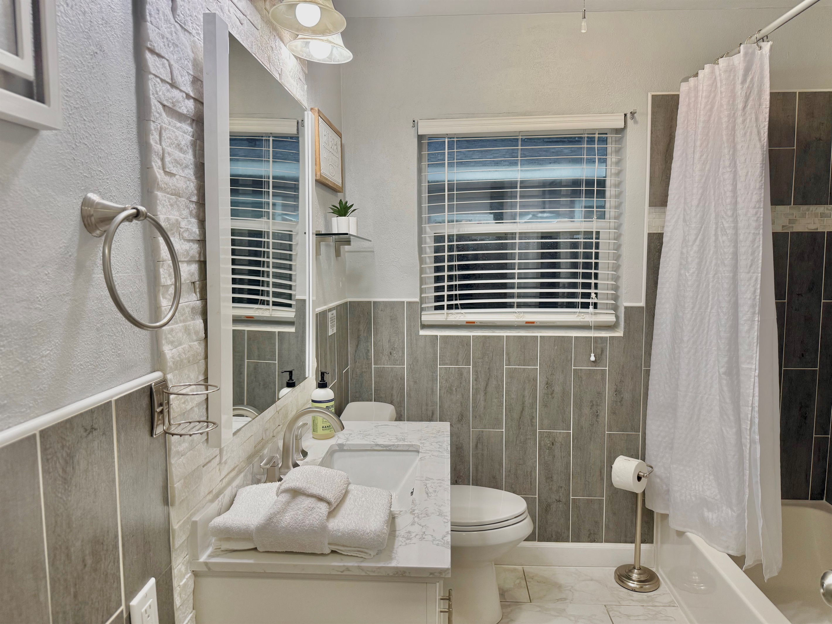 With its large mirror, natural light, and neutral palette, this bathroom offers a refreshing start and relaxing end to your day.