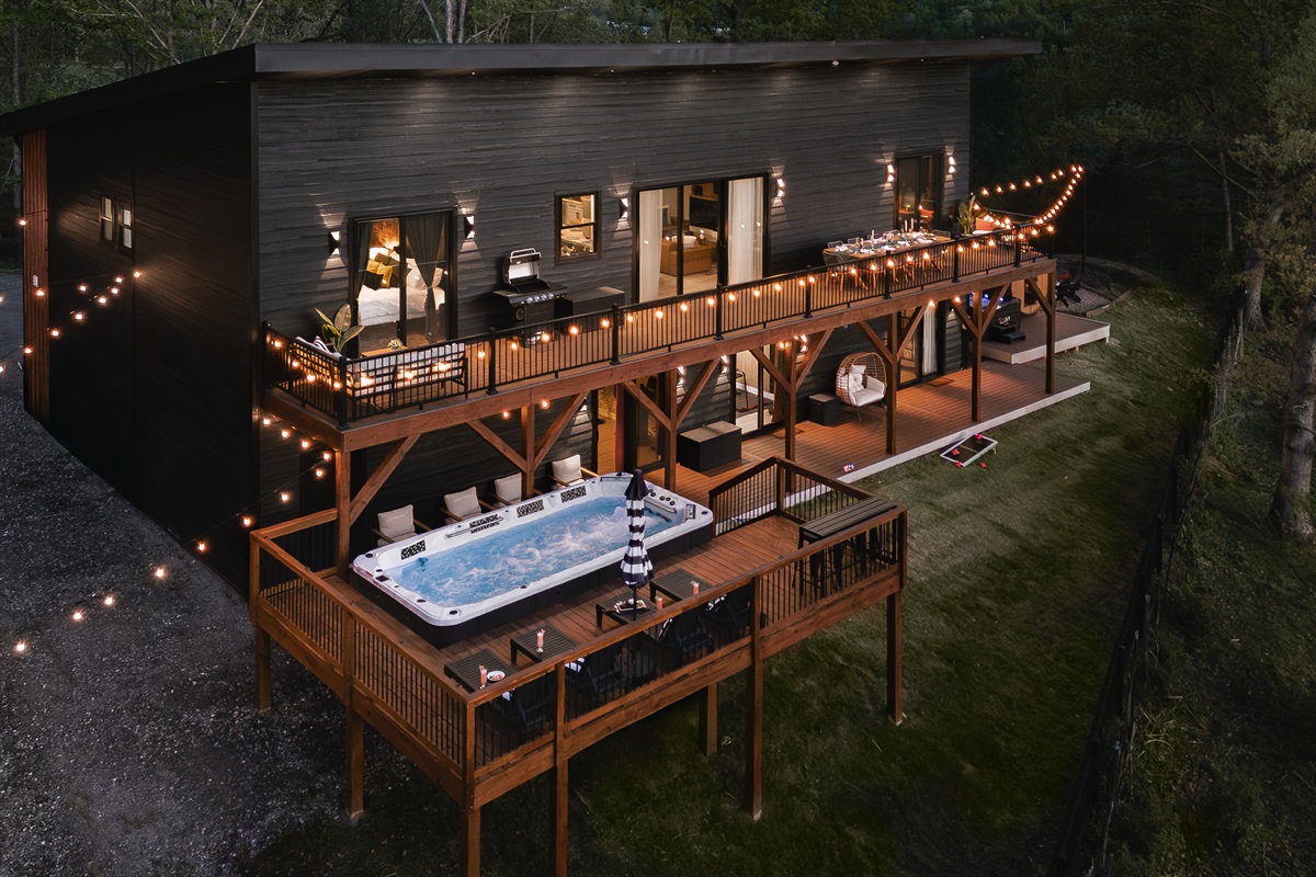 {Welcome} Nighttime at Summit House — soak in the swim spa on the elevated deck beneath glowing string lights, sharing stories over a glass of wine with mountain views all around. The perfect way to unwind and end the night.