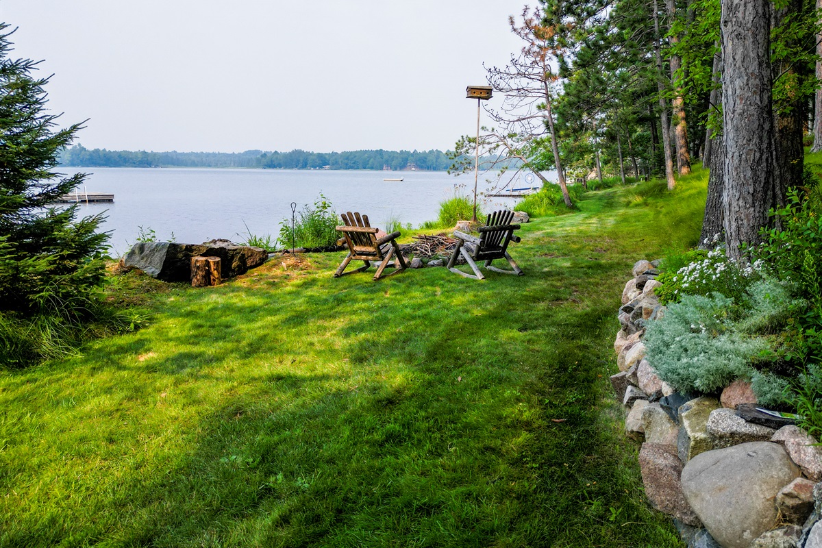 Warm up in the morning or evening at the firepit located in the grass and garden right on the lake