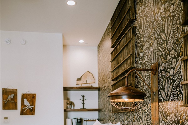 Lazy Spur Suite bedroom from a fresh angle &mdash; modern Western lighting, a custom patterned feature wall, and curated Hill Country details.