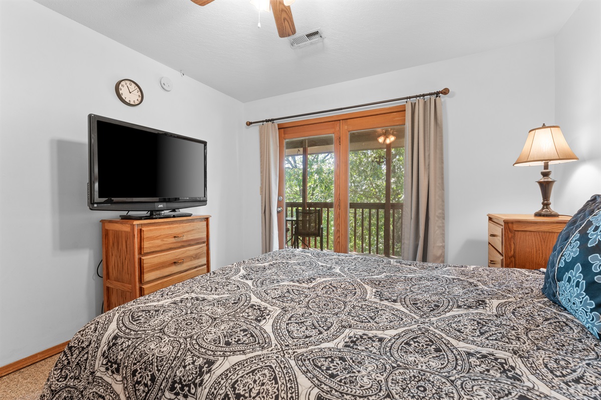 Soft lighting, a queen bed, and deck-side windows make the primary bedroom feel restful and private.