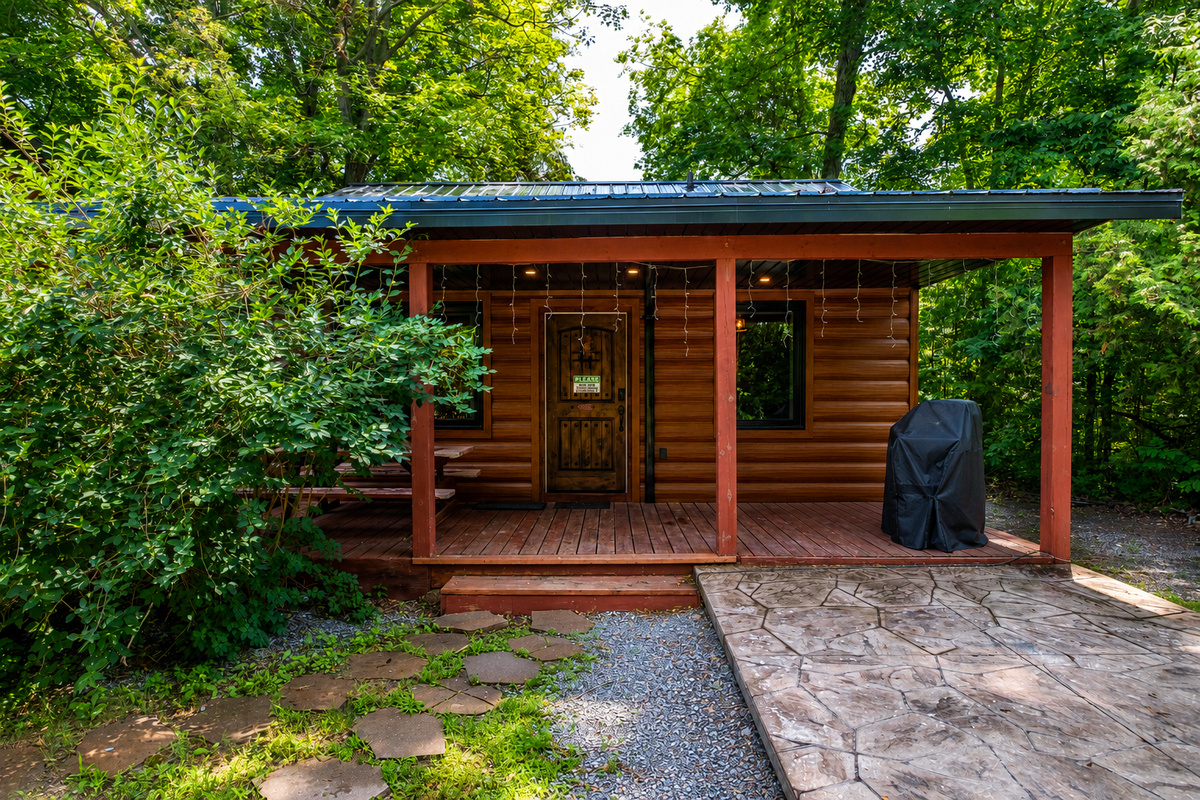 Cottage #6 exterior with covered porch and wooded surroundings