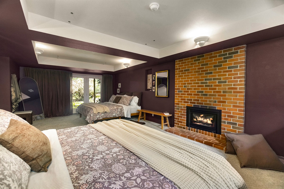 The lower bedroom has two full king-sized beds, is drenched in warm cozy colors, and features a dedicated fireplace.