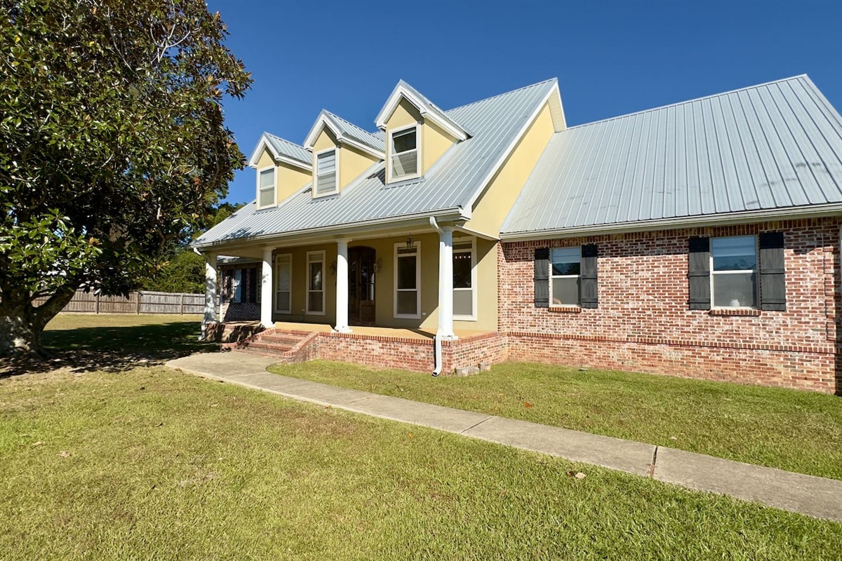 A well-kept lawn and mature tree frame the property, enhancing its cozy suburban charm.
