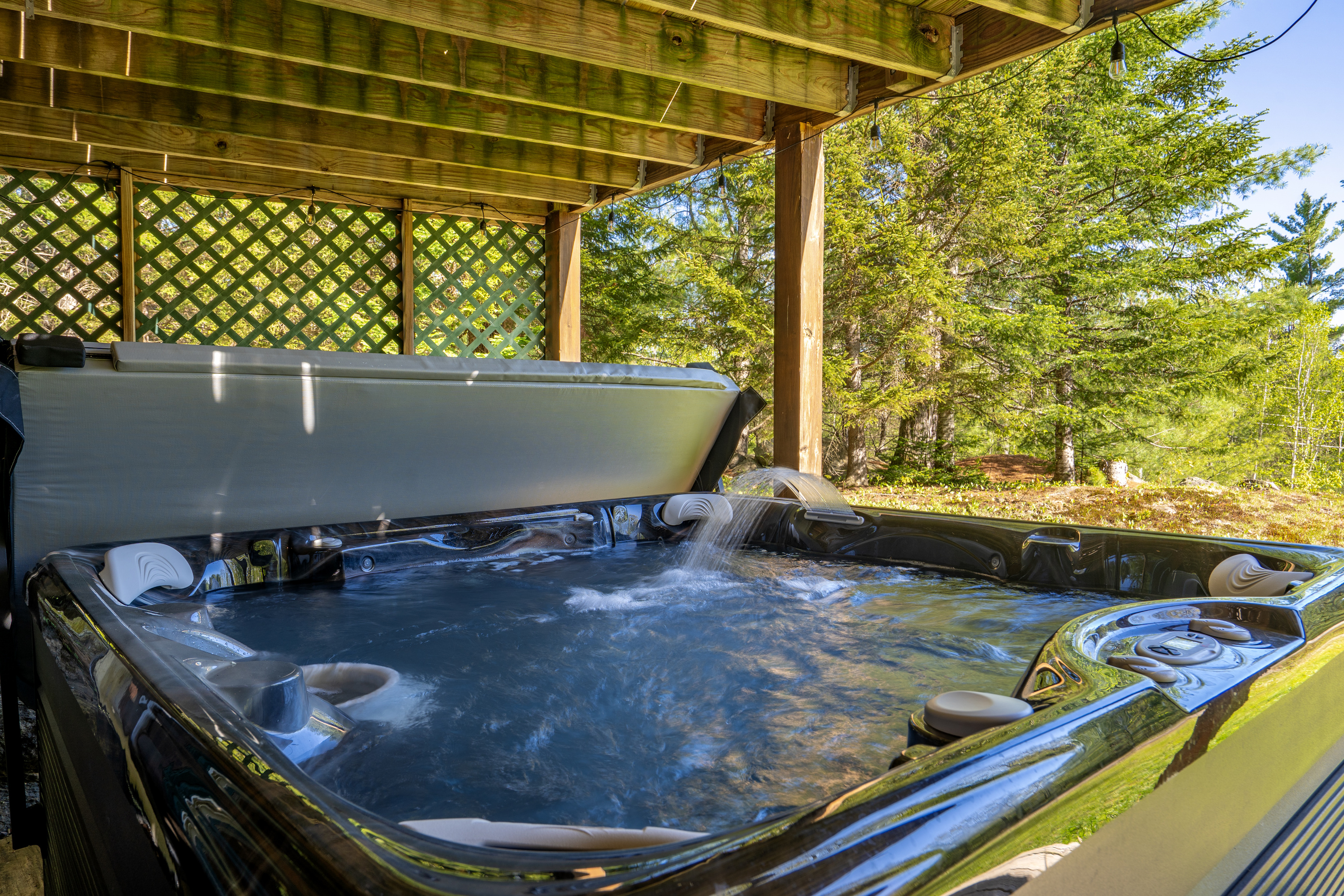 Unwind year-round in the private hot tub, tucked beneath a covered deck and surrounded by peaceful woodland views.