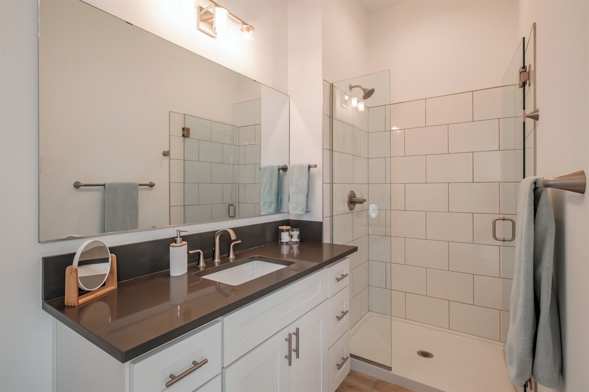 Another upper-level master bath with a fresh, modern look featuring crisp white tile and a generous walk-in shower. 