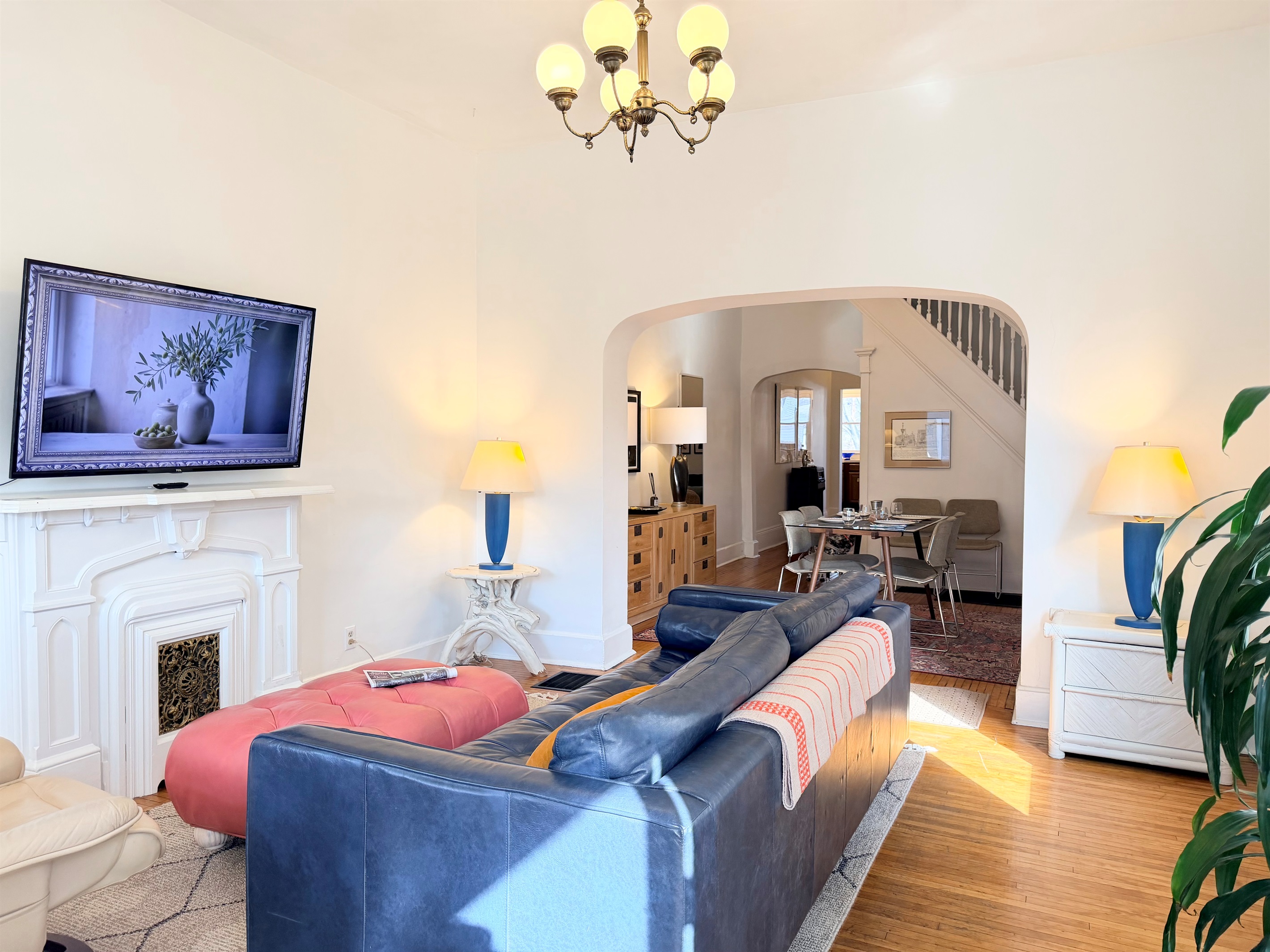 A bright, open view highlighting the room’s scale, natural light, classic arches, and early-1920s charm.