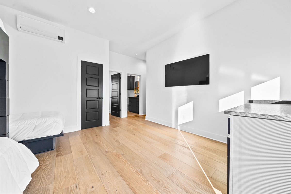 This cheerful bunk room offers a refreshing blend of modern style, ample natural light, and thoughtful sleeping arrangements for comfort and practicality.