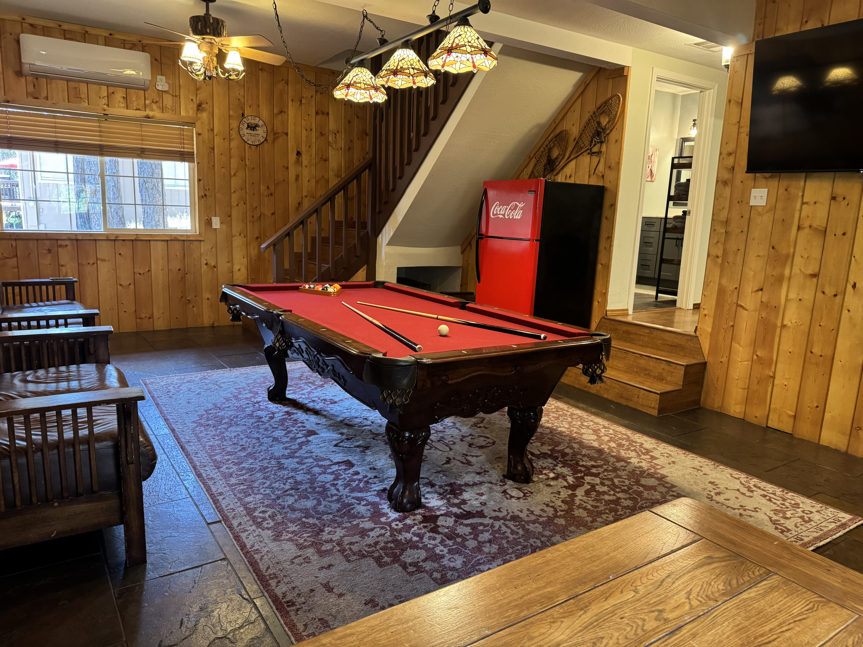 Step into cozy room with a pool table, wood fireplace, smart TV, and plenty of seating. Perfect for relaxing and entertaining.