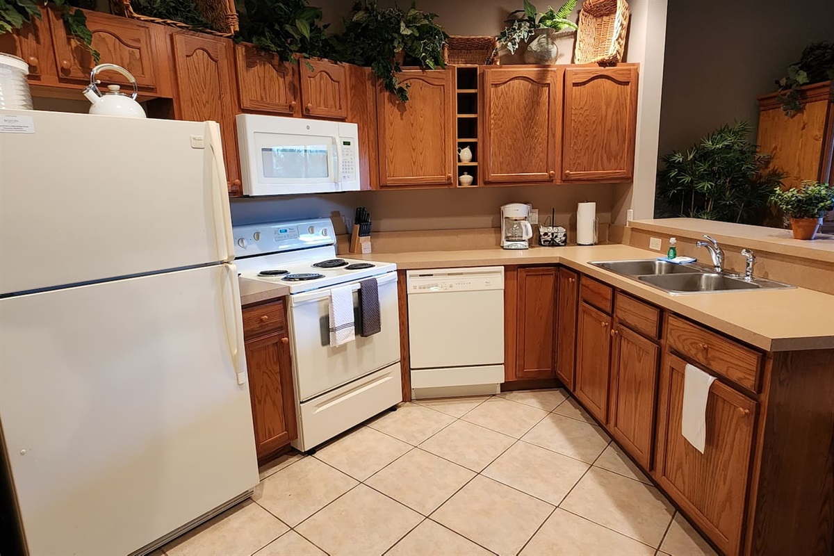 Functional kitchen featuring full-size appliances, plenty of cabinet storage, and a convenient open layout.