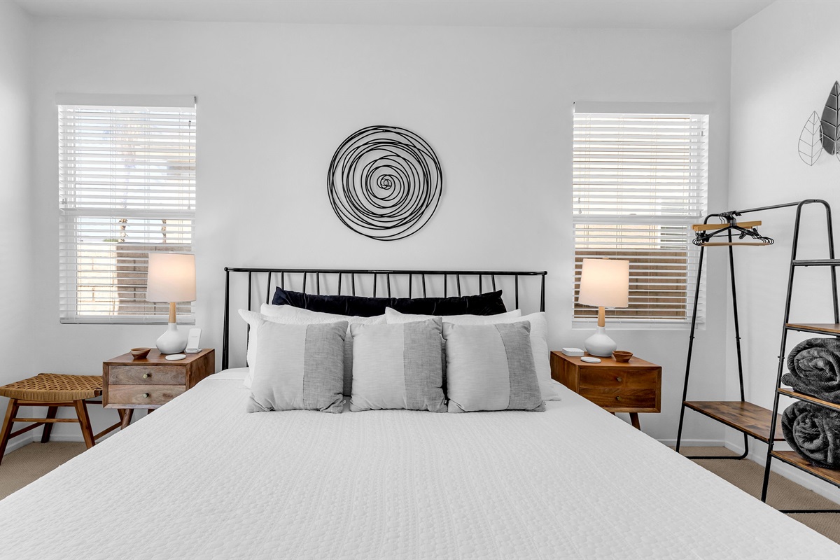 Bright and airy primary bedroom featuring modern décor, soft linens, and natural light.