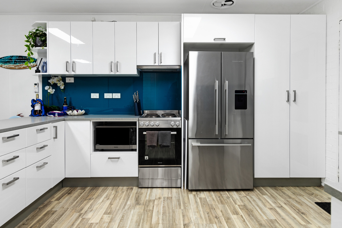 A second kitchen downstairs adds flexibility at Skye’s Beach House, with fridge, sink and bench space beside the lower living area.