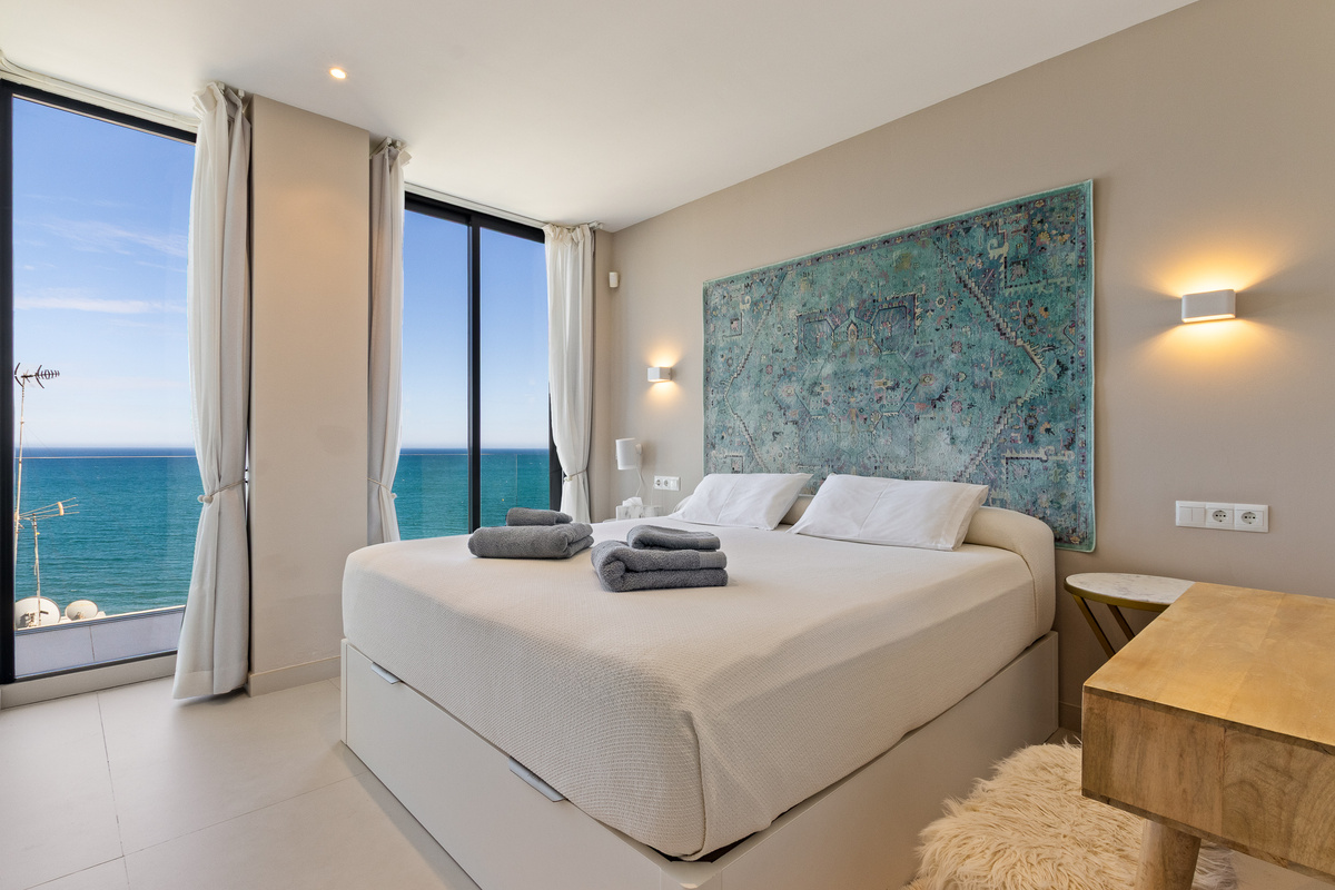 Sea-view bedroom with large windows and calming coastal design