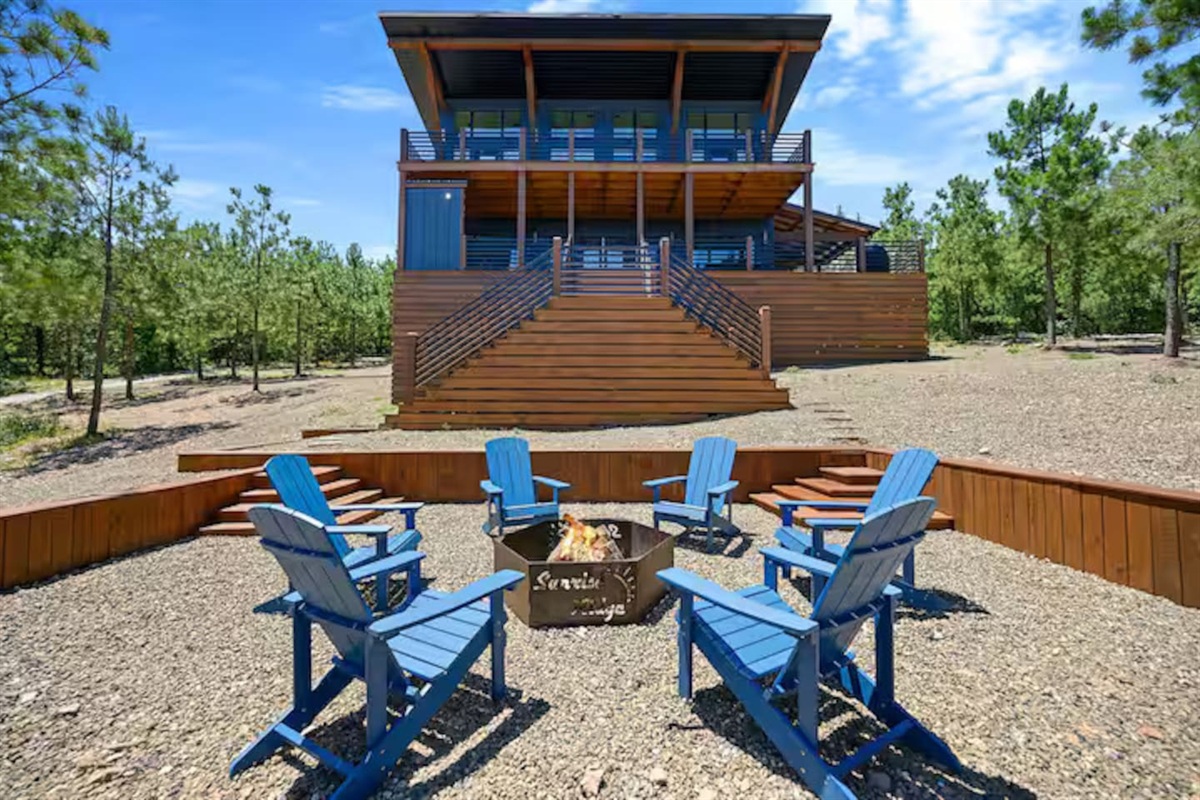 Exterior view of cabin with fire pit gathering area.