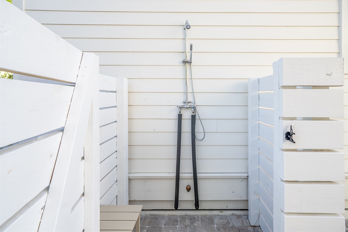 Enjoy an outdoor shower with hot & cold water and a pavered floor