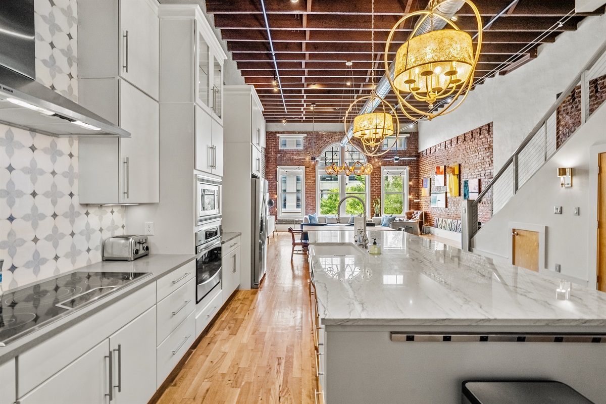 Fully equipped chef’s kitchen with granite countertops and bar seating.
