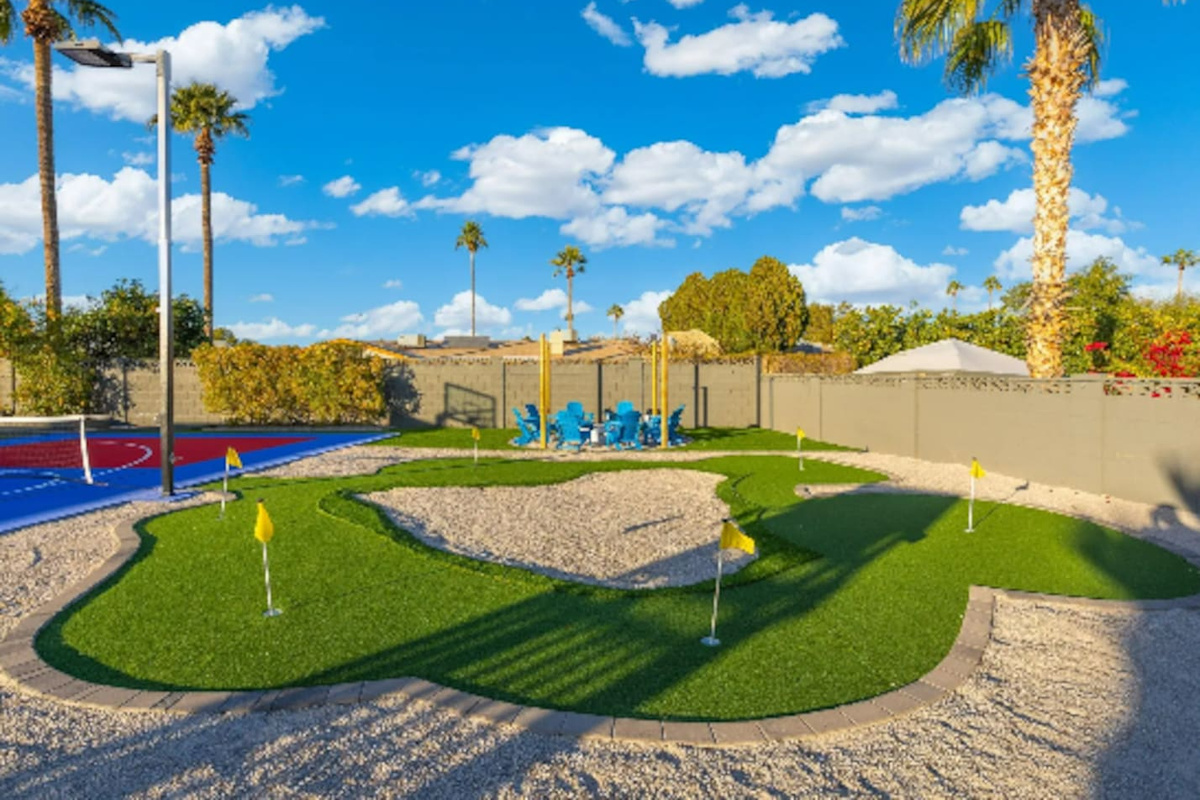 Multiple greens and flags make this putting course feel like its own mini golf getaway, shaded palms included.