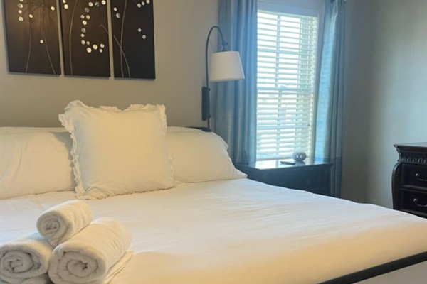 Spacious bed with a comfortable mattress and soft linens, providing the perfect retreat for a restful night’s sleep.