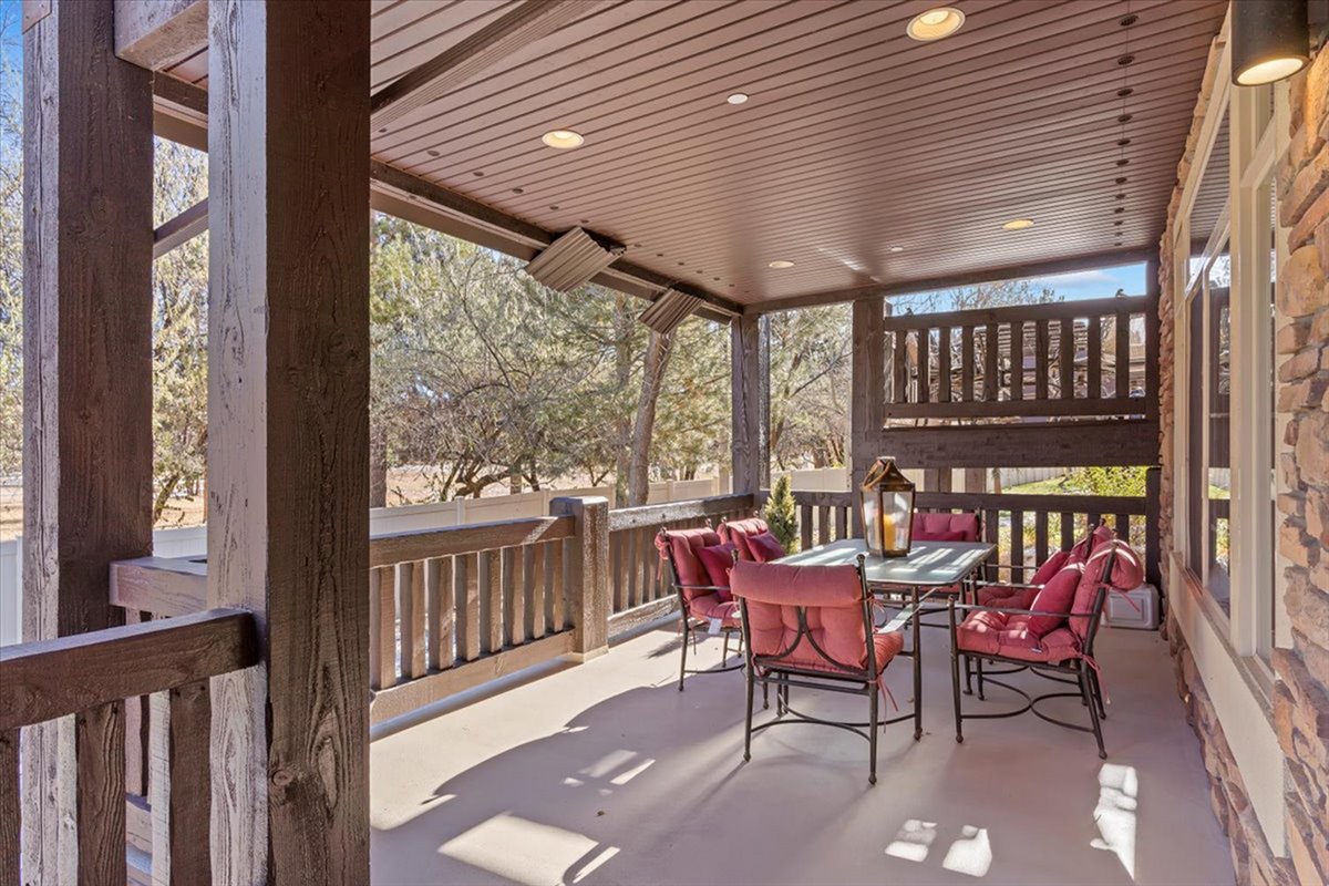 A covered outdoor deck with comfortable seating, offering a peaceful setting for morning coffee or evening relaxation.