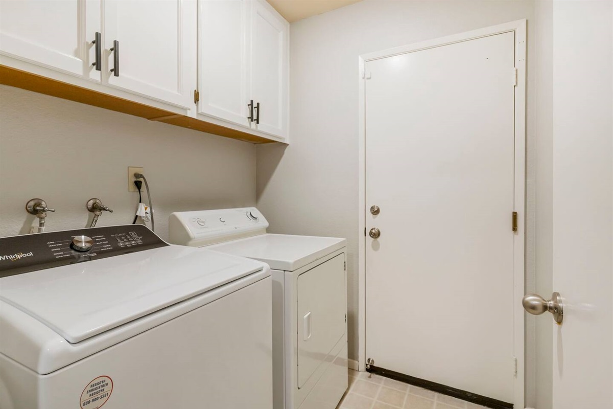 The laundry room boasts a brand new washer, a dryer and detergent for your convenience. It includes practical storage space and provides direct access to the garage, streamlining chores and keeping the home organized.