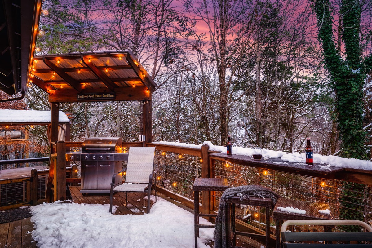 Backyard deck with a Weber charcoal grill (different from pictured) and outdoor dining furniture