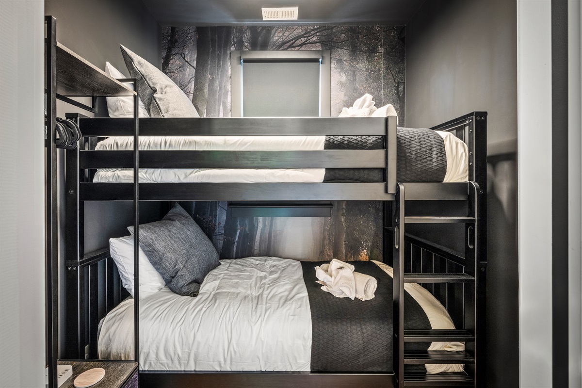 Tucked away with its own enchanted forest mural, this cozy twin-over-twin bunk room is a favorite for kids and teens—compact, fun, and full of charm.