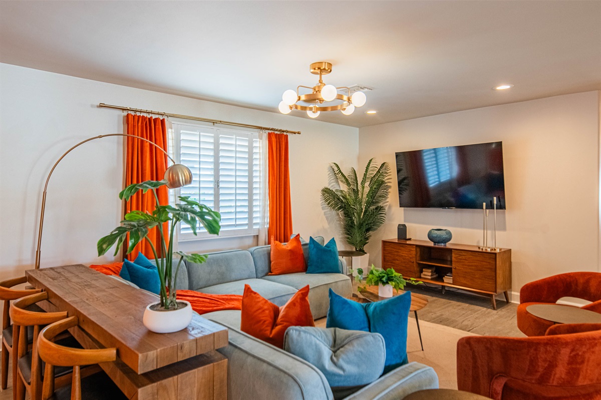 Comfortable designer living space with modern furnishings, smart TV, and cozy seating — ideal for relaxing after golf days, Old Town nights, or pool time.