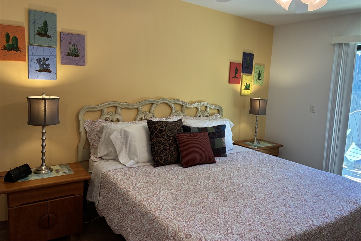Bedroom with sliding glass door to fenced backyard.