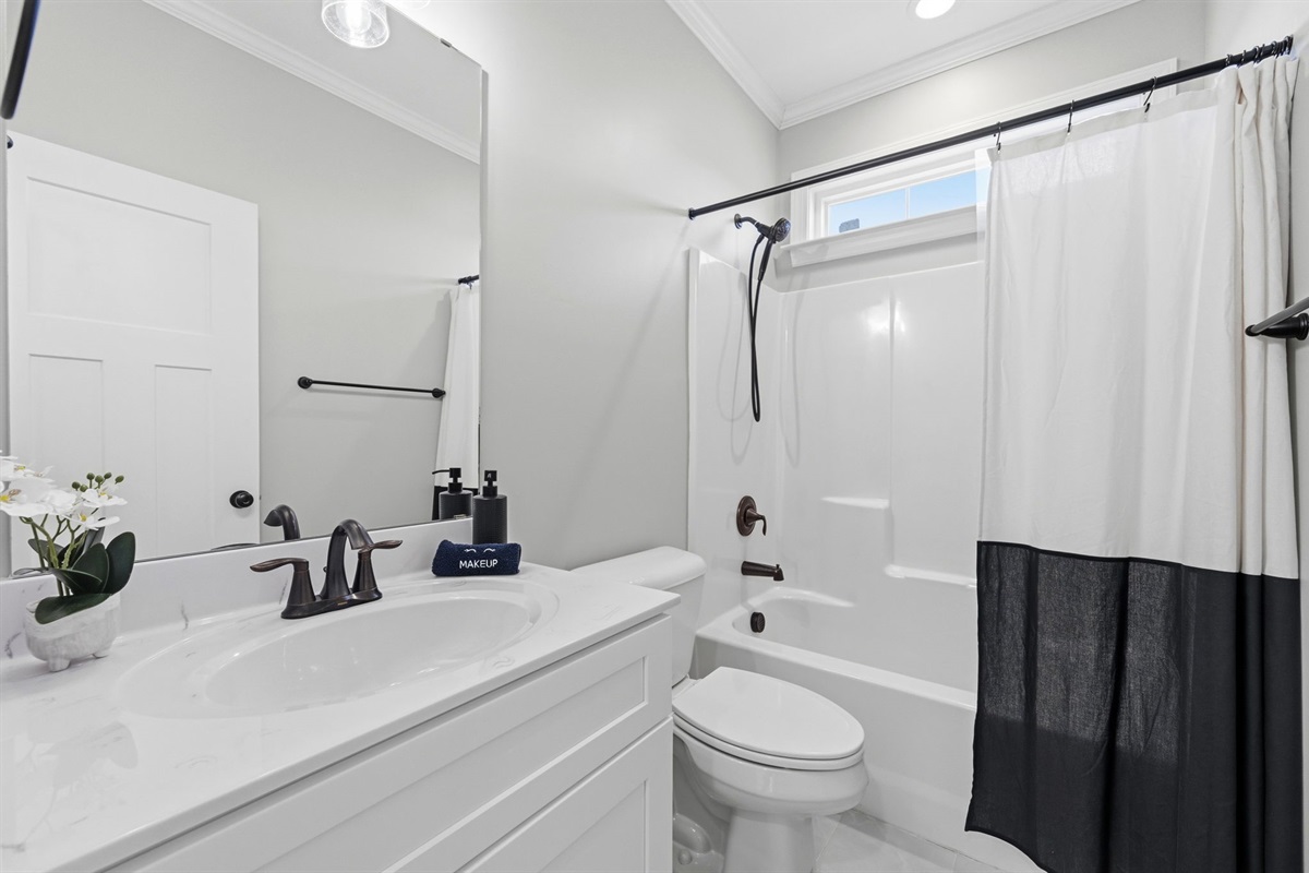 Bright main-level bathroom featuring modern finishes, a full tub and shower combo, and plenty of space to refresh after the beach