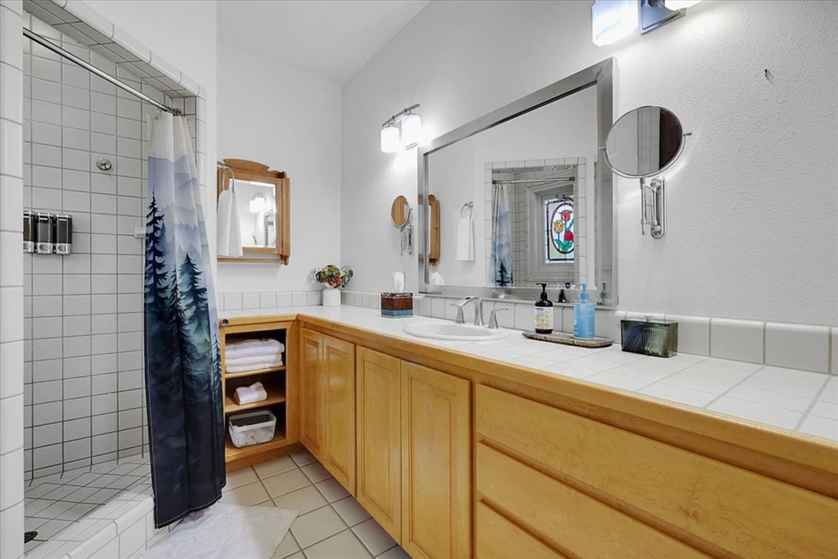 Full Bathroom 1 with a shower, vanity storage, and fresh towels ready for guests.

