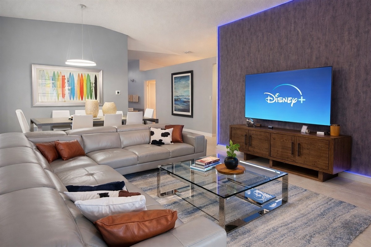 Modern living room with a large sectional sofa and a 70" Roku streaming TV for entertainment.