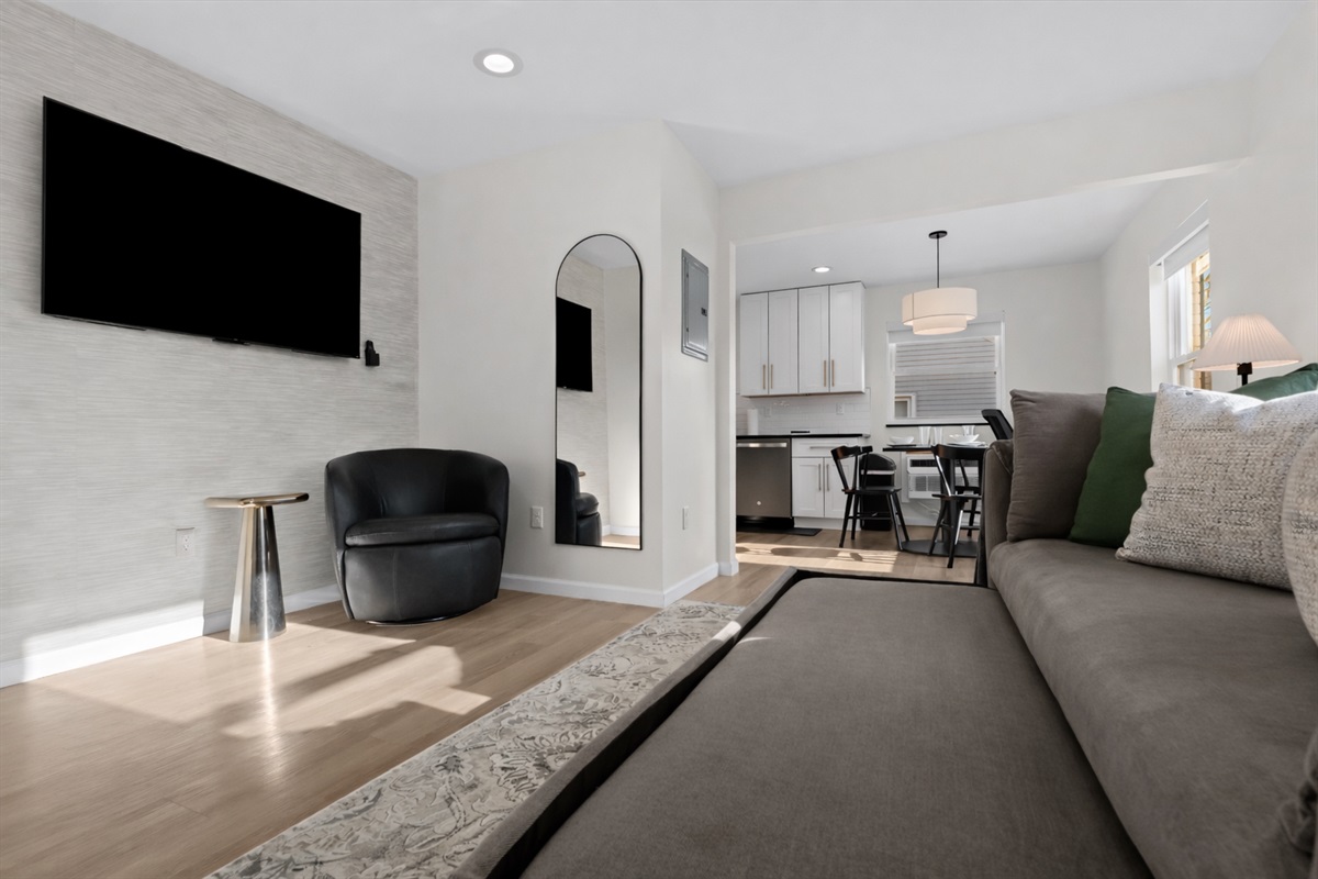 Open, modern living space with a pull-out sofa, smart TV, and stylish seating—perfect for relaxing, entertaining, or hosting additional guests.