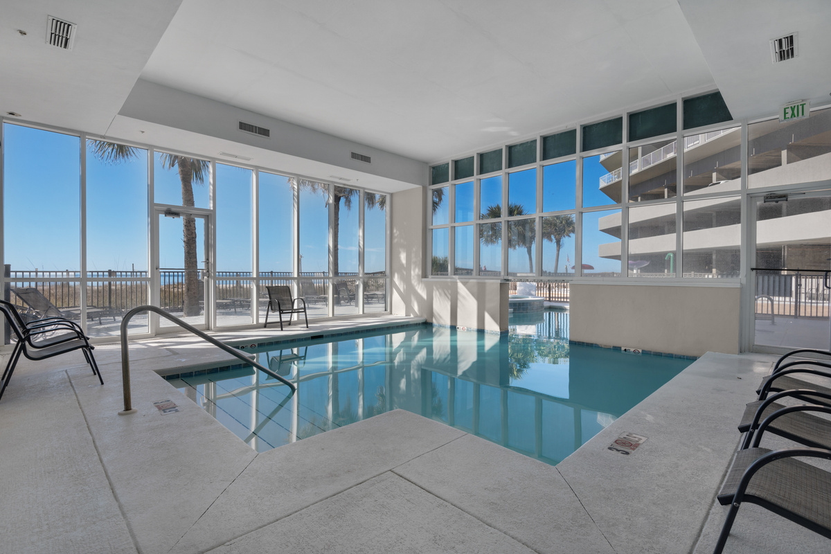 Indoor pool with Gulf views through the surrounding windows.