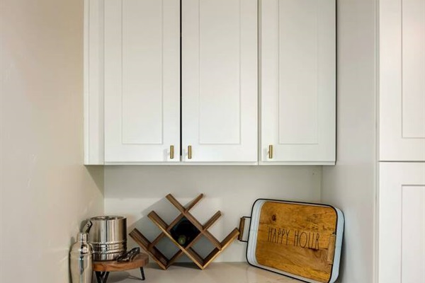 Minibar area with a wine rack, cocktail set, cocktail glasses (above), and a serving tray.