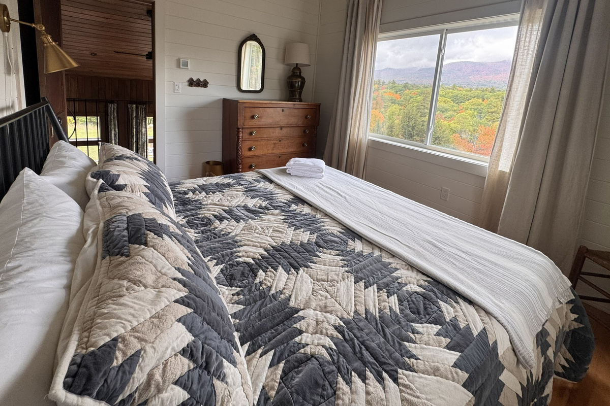Relax in this cozy second-floor bedroom while enjoying picturesque mountain and autumn foliage views.