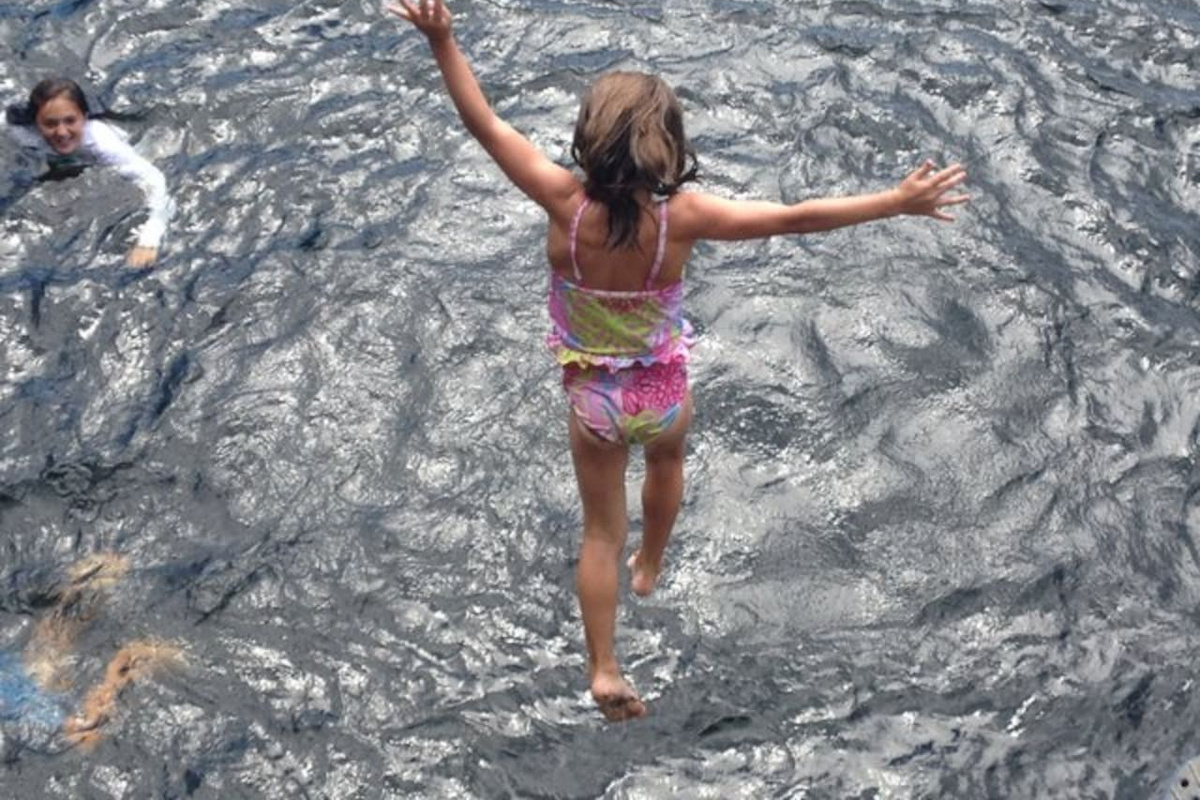 In flight from the upper cliff at our swimming hole.