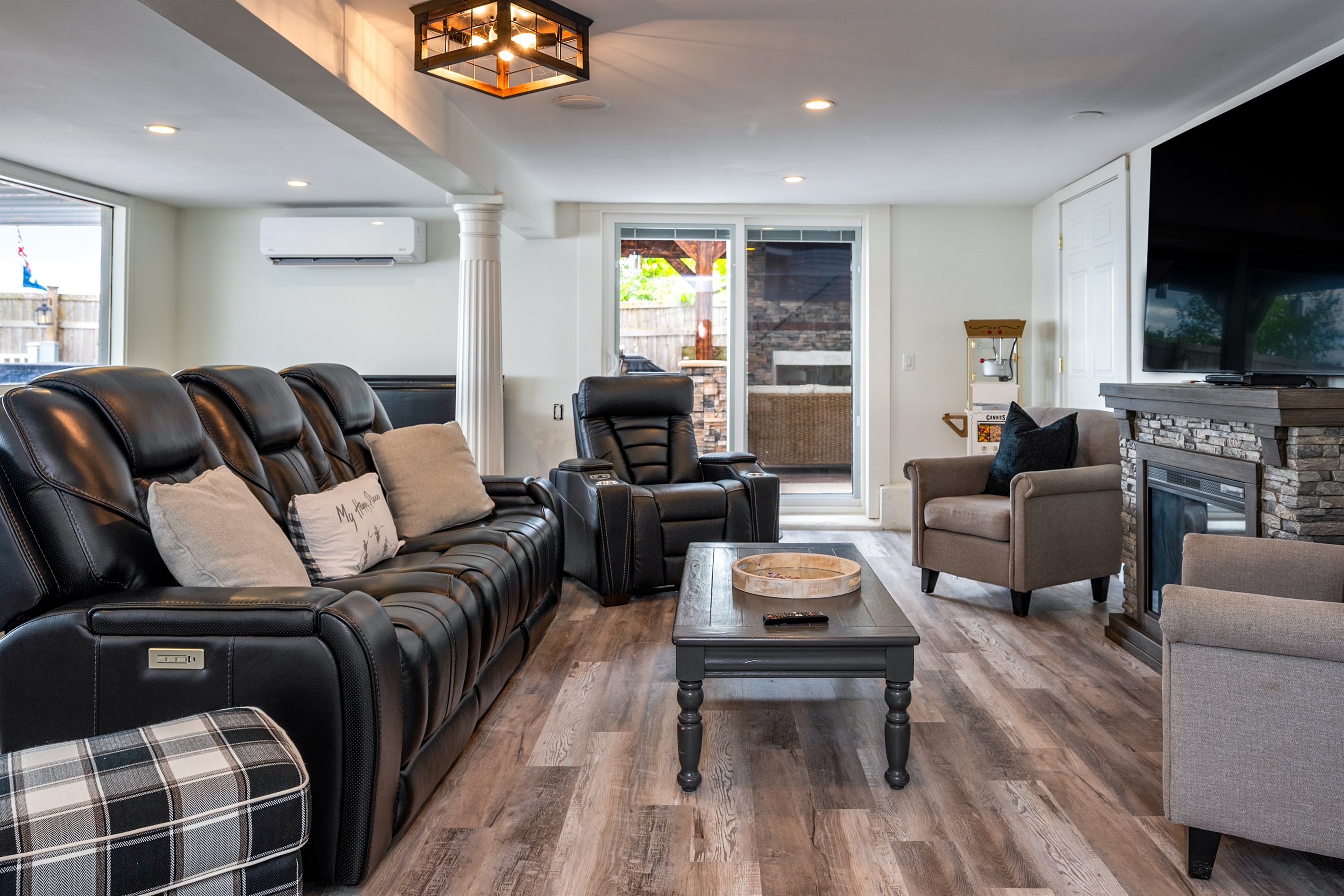Kick back in this inviting living room with leather recliners, a stone fireplace, and big-screen TV 🔥🎬🛋️
