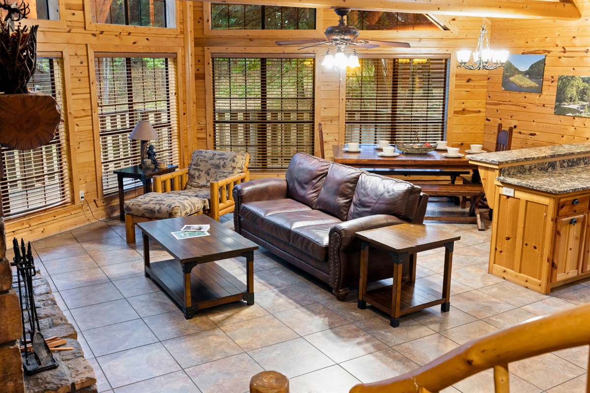 Living area with sofa seating, big windows, and cabin charm.