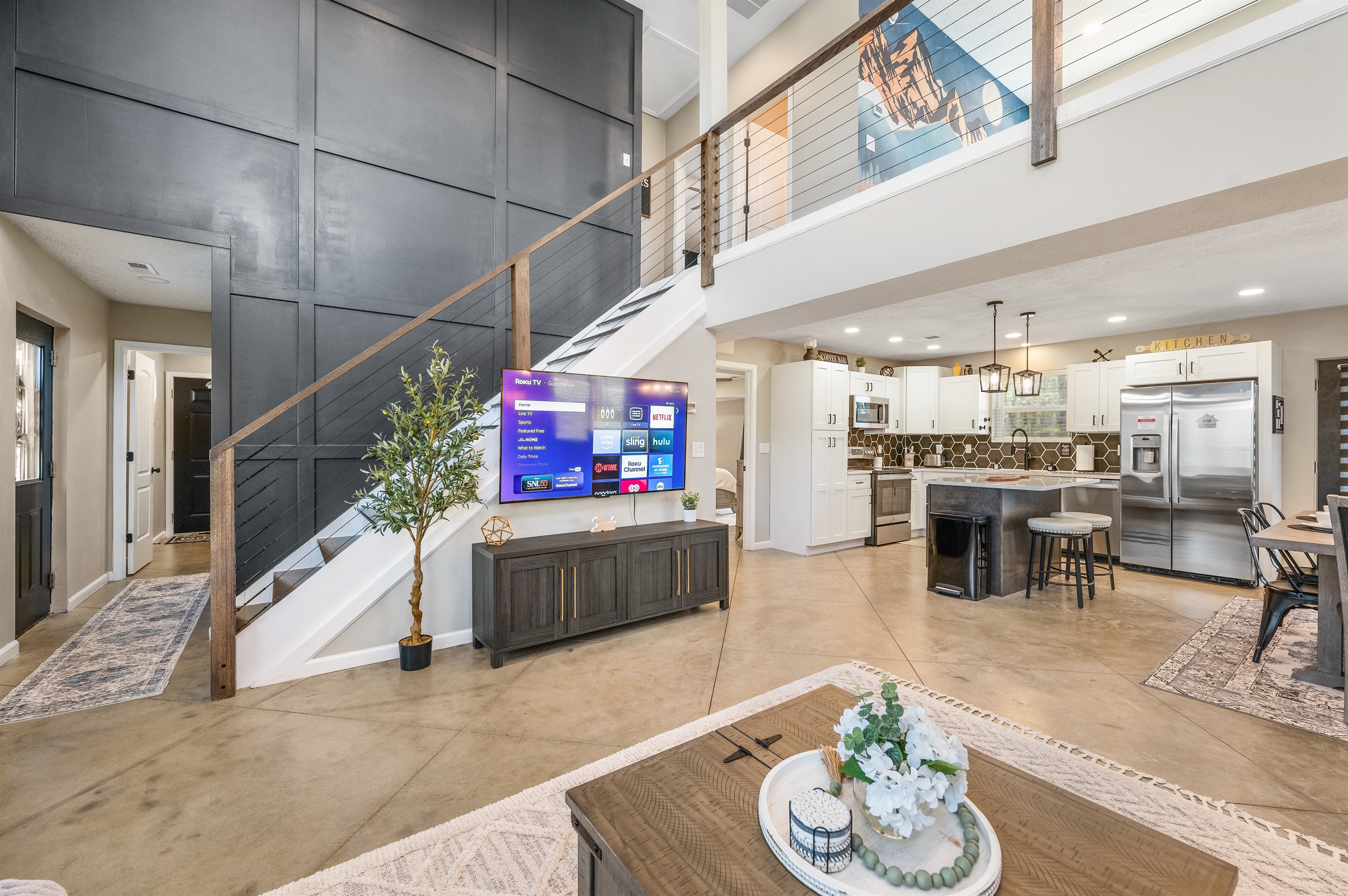 The open-concept living room makes it easy to stay connected—whether you’re cooking in the kitchen, lounging on the sectional, or gathering for a movie on the 65” smart TV.
