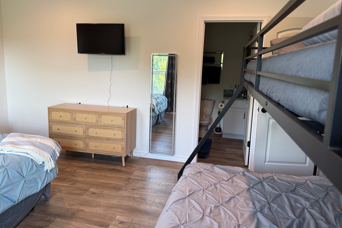 Bathroom door from bedroom #3. Large mirror with built lights and dresser.